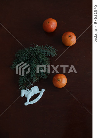 Christmas Toy horse, tangerines and pine cone. Winter holiday items for home decor. Flat lay Christmas Toy horse, tangerines and pine cone. Winter holiday items for home decor. Flat lay 97631945