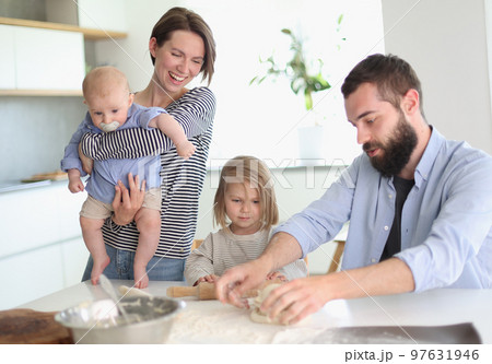 Young parents playing with children in the kitchen Young parents playing with children in the kitchen 97631946