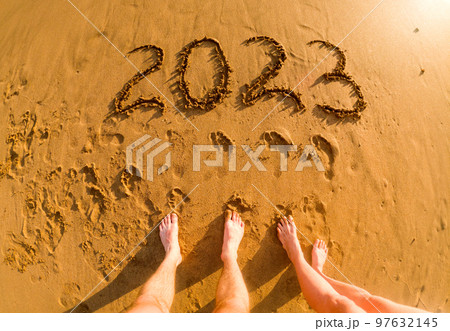 2023 written in sand and feet of a couple New Year on the beach 2023 written in sand and feet of a couple New Year on the beach 97632145