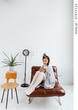 Sweet woman relaxing with hot beverage covered blanket 97633125