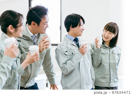 工場・工務店などの中小企業で休憩にコーヒーを飲みながら談笑する作業着を着た従業員・スタッフの横顔 工場・工務店などの中小企業で休憩にコーヒーを飲みながら談笑する作業着を着た従業員・スタッフの横顔 97634471
