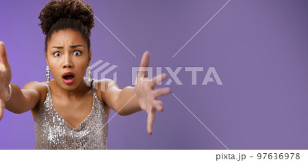 Close-up excited african woman in stylish fashionable silver glittering dress extend arms fowards frowning gasping look concerned worry friend fall standing concerned rushing help, blue background 97636978
