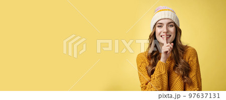 Shush listen. Portrait attractive flirty smiling devious cute european woman have secret showing shh gesture index finger pressed lips sharing interesting rumor, standing happily yellow background Shush listen. Portrait attractive flirty smiling devious cute european woman have secret showing shh gesture index finger pressed lips sharing interesting rumor, standing happily yellow background 97637131
