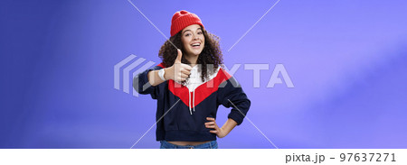 Nice work, keep up. Delighted and supportive charming sportswoman in winter beanie, sweatshirt and watch showing thumbs up with satisfied smile, giving approval, liking and cheering great effort Nice work, keep up. Delighted and supportive charming sportswoman in winter beanie, sweatshirt and watch showing thumbs up with satisfied smile, giving approval, liking and cheering great effort 97637271