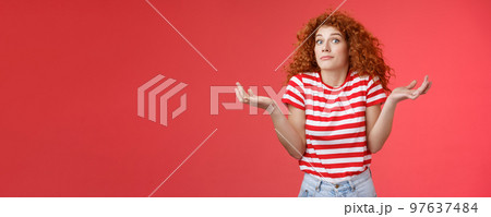 Not know ask someone else. Clueless unaware cute redhead curly-haired charming modern girl uncertain where spend summer holidays shrugging hands spread sideways smirking confused red background Not know ask someone else. Clueless unaware cute redhead curly-haired charming modern girl uncertain where spend summer holidays shrugging hands spread sideways smirking confused red background 97637484