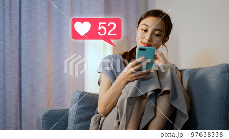 夜にスマートフォンを操作をする若い女性 夜にスマートフォンを操作をする若い女性 97638338