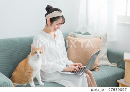 家で猫と一緒にテレワーク・リモートワークする女性 97639097