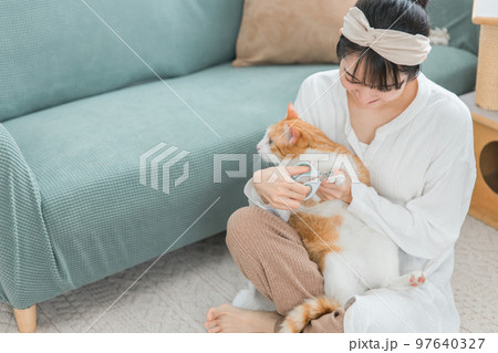 猫の爪切りをする飼い主のアジア人女性 猫の爪切りをする飼い主のアジア人女性 97640327