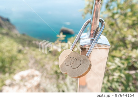 Wedding Heart Golden Lock on stainless iron fence. Valentine's day. Symbol of eternal love. A wedding tradition all over the world to hinder the lock. Monument on the wedding day. 97644154