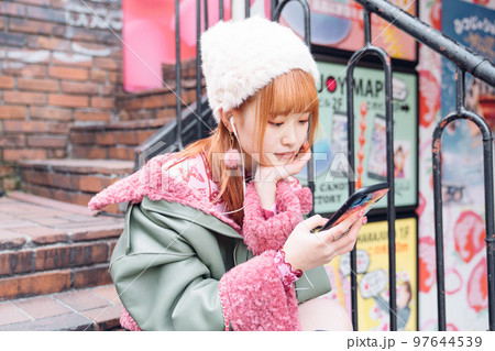音楽を聴く原宿系ギャルファッションの女の子 97644539