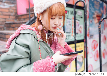 音楽を聴く原宿系ギャルファッションの女の子 97644541