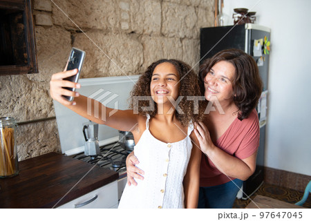 Multiracial family taking a selfie in the kitchen of their home 97647045