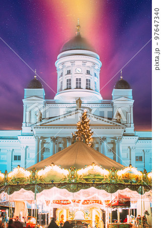 Helsinki, Finland. Xmas Market On Senate Square With Holiday Carousel And Famous Landmark Is Lutheran Cathedral At Winter Evening. Amazing Sky Clouds. Very Peri. Bright Purple Lavander Colors Of Sky Helsinki, Finland. Xmas Market On Senate Square With Holiday Carousel And Famous Landmark Is Lutheran Cathedral At Winter Evening. Amazing Sky Clouds. Very Peri. Bright Purple Lavander Colors Of Sky 97647340