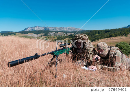 Army soldier holding sniper rifle with scope and aiming in forest. War, army, technology and people concept 97649401