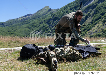 Special operations soldiers team preparing tactical and communication gear for action battle. Long distance sniper team in checking gear for action 97649458
