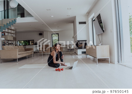 Young Beautiful Female Woman with Trainer via Video Call Conference in Bright Sunny House. Healthy Lifestyle, Wellbeing and Mindfulness Concept. Young Beautiful Female Woman with Trainer via Video Call Conference in Bright Sunny House. Healthy Lifestyle, Wellbeing and Mindfulness Concept. 97650145