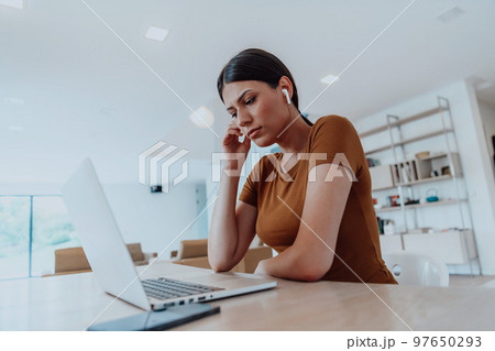Woman sitting in living room using laptop look at cam talk by video call with business friend relatives, head shot. Job interview answering questions. 97650293