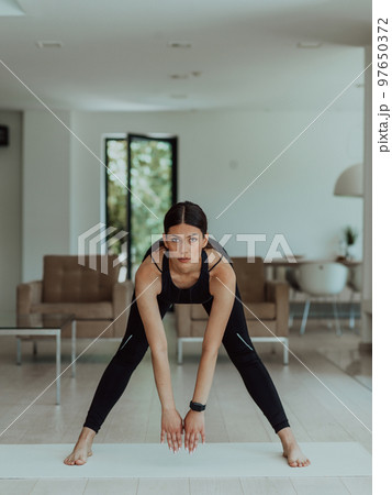 Young Beautiful Female Exercising, Stretching and Practising Yoga with Trainer via Video Call Conference in Bright Sunny House. Healthy Lifestyle, Wellbeing and Mindfulness Concept. Young Beautiful Female Exercising, Stretching and Practising Yoga with Trainer via Video Call Conference in Bright Sunny House. Healthy Lifestyle, Wellbeing and Mindfulness Concept. 97650372