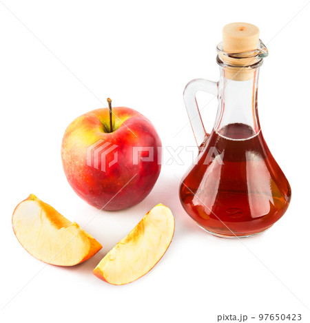 Vinegar in a jug and ripe apples isolated on a white. Vinegar in a jug and ripe apples isolated on a white. 97650423