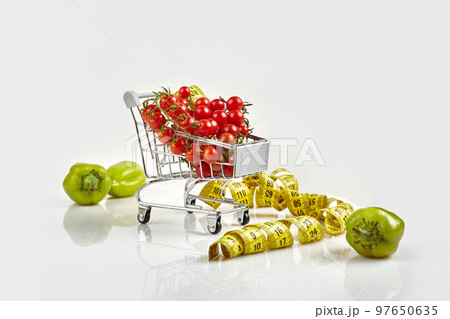 Shopping trolley full of tomatoes, pepper on white background 97650635