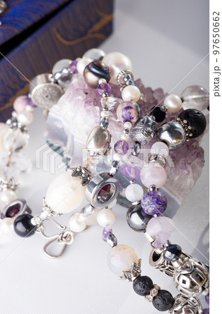 stylish jewelry bracelets with natural semiprecious and amethyst crystal around white background. hobby and fashion concept. close up stylish jewelry bracelets with natural semiprecious and amethyst crystal around white background. hobby and fashion concept. close up 97650662