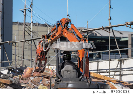 住宅解体の廃材を処理する重機 97650858