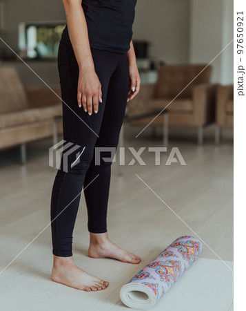 A woman in sports clothes resting after a hard online training session 97650921