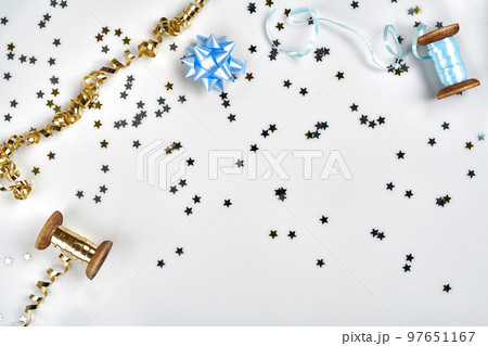 Delicate wavy ribbons and metallic star shaped confetti isolated on white background. Christmas holidays decoration concept. Delicate wavy ribbons and metallic star shaped confetti isolated on white background. Christmas holidays decoration concept. 97651167