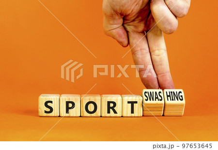 Sport or sportswashing symbol. Concept words Sport and Sportswashing on wooden cubes. Businessman hand. Beautiful orange table orange background. Business sport sportswashing concept. Copy space. 97653645