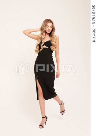Young blonde woman in black evening dress Young blonde woman in black evening dress 97653760