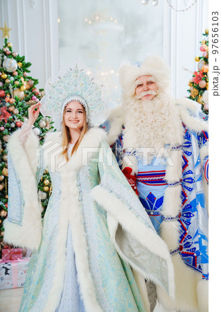 a Father Frost and Snow Maiden in blue costume in the room with christmas trees a Father Frost and Snow Maiden in blue costume in the room with christmas trees 97656103