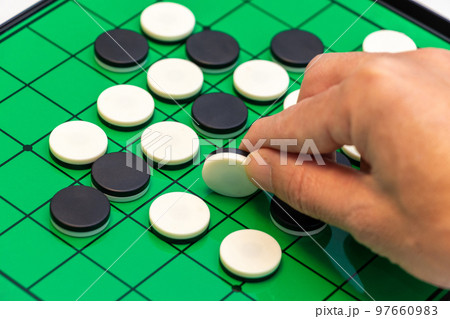 オセロの石をつまんで裏返す 97660983