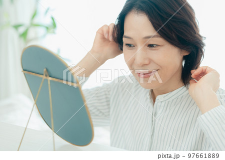 ヘアスタイルをチェックするミドル女性 97661889