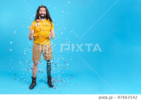 Happy man with a leg prosthesis surrounded by flying confetti Happy man with a leg prosthesis surrounded by flying confetti 97663542