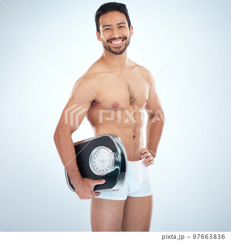 Asian man, scale and lose weight wellness for fitness workout, exercise goals motivation and health training in studio. Self care, healthy body and personal trainer happiness for happy lifestyle Asian man, scale and lose weight wellness for fitness workout, exercise goals motivation and health training in studio. Self care, healthy body and personal trainer happiness for happy lifestyle 97663836
