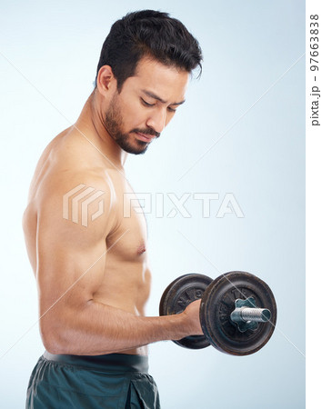 Man, fitness and dumbbell in studio for muscle, wellness and self care by blue background with focus. Model, bodybuilder workout and training for health, body or development with exercise by backdrop Man, fitness and dumbbell in studio for muscle, wellness and self care by blue background with focus. Model, bodybuilder workout and training for health, body or development with exercise by backdrop 97663838