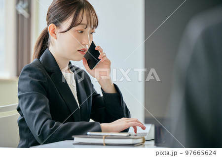 デスクで電話をする若い女性 97665624