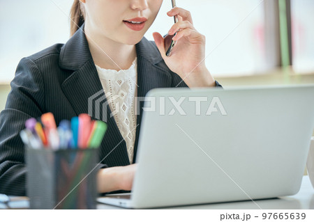 デスクで電話をする若い女性 デスクで電話をする若い女性 97665639