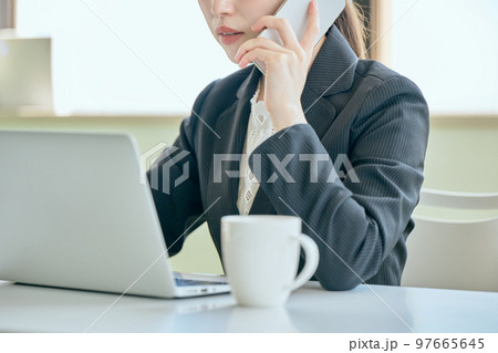 デスクで電話をする若い女性 97665645