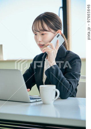 デスクで電話をする若い女性 97665646