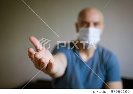 A man in a medical mask pulls his arms forward A man in a medical mask pulls his arms forward 97669100