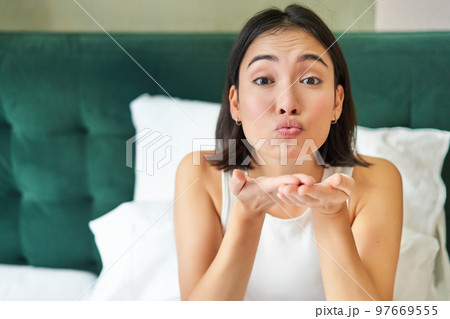 Beautiful korean girlfriend, girl in bed, sending air kiss at camera, lying in bed in her bedroom, waking up early Beautiful korean girlfriend, girl in bed, sending air kiss at camera, lying in bed in her bedroom, waking up early 97669555