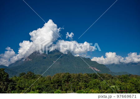 View of Doi Luang Chiang Dao, the third highest mountain in Thailand, seen with dramatic clouds and colorful sky with camping tents in foreground View of Doi Luang Chiang Dao, the third highest mountain in Thailand, seen with dramatic clouds and colorful sky with camping tents in foreground 97669671