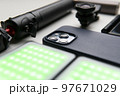 Equipment for shooting video on a smartphone. Microphone, LED lamp, tripod, lens smartphone are on a white table 97671029