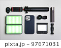 Equipment for shooting video on a smartphone. Microphone, LED lamp, tripod, lens smartphone are on a white table 97671031