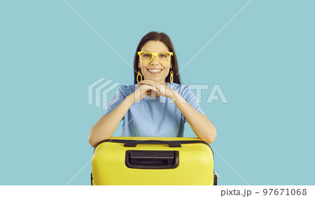 Portrait of happy beautiful young woman traveler with yellow suitcase on light blue background. Portrait of happy beautiful young woman traveler with yellow suitcase on light blue background. 97671068