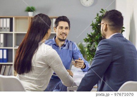 Happy family couple signing contract together in office Happy family couple signing contract together in office 97671070
