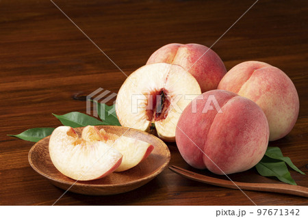 葉を添えた桃とカットして木皿に盛った桃_夏が旬の果物 97671342