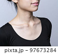 襟元を大きく開けた女性　襟元を大きく出した女性　デコルテにシワのない女性　デコルテのケアをする女性 97673284
