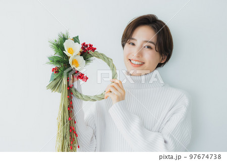 しめ縄飾りを持つ女性 97674738